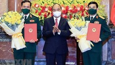 Chủ tịch nước Nguyễn Xuân Phúc trao quyết định thăng quân hàm, hoa chúc mừng Bộ trưởng Quốc phòng Phan Văn Giang (phải) và Thứ trưởng Vũ Hải Sản. Ảnh: TTXVN