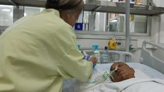 Bà Lan chăm sóc cho con trai tại viện.