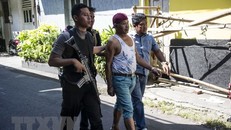 Cảnh sát bắt giữ một đối tượng tình nghi để thẩm vấn sau vụ tấn công ở Surabaya, Indonesia ngày 14/5 vừa qua. (Ảnh: AFP/TTXVN)
