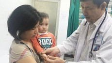 Một bệnh nhi mắc tay chân miệng điều trị tại khoa Truyền nhiễm đang được bác sĩ Hải thăm khám. Ảnh: K.C.