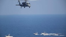 Một trực thăng quân sự MH-60 Seahawk của Mỹ đang bay phía trên đầu các tàu tuần tra của Iran ở gần nơi Lực lượng Vệ binh Cách mạng Iran tập trận hôm 21/12. Ảnh: AP