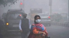 Một phụ nữ Ấn Độ mang khẩu trang để đối phó với bầu không khí ô nhiễm mịt mù - (Ảnh: AFP).