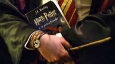 Một fan của Harry Potter cầm cuốn sách trong một sự kiện kỷ niệm 20 năm xuất bản truyện. Ảnh: Tân Hoa xã.