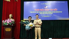 Thiếu tá Đào Việt Long, Phó Trưởng phòng Cảnh sát giao thông, Công an TP Hà Nội tặng hoa chúc mừng tác giả đoạt giải Nhất.