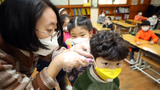 Một giáo viên kiểm tra thân nhiệt của học sinh trong bối cảnh lo ngại về dịch COVID-19 vùng phát khi các trường học trở lại sau kỳ nghỉ Đông ở Hàn Quốc. (Nguồn: Yonhap