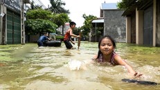 Trẻ em ngoại thành Hà Nội nô đùa trong nước lũ