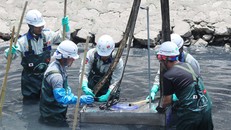 Các kỹ sư và công nhân hạ thiết bị xử lý ô nhiễm xuống sông Tô Lịch sáng 16/5. Ảnh: Võ Hải.