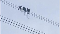 Lực lượng chức năng giải cứu nam thanh niên ngồi trên đường dây điện cao thế.