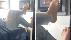 Người phụ nữ dùng chân vuốt màn hình tivi trên máy bay