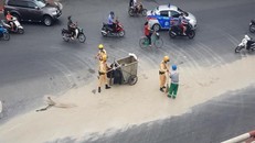 Lực lượng chức năng cùng nhân viên vệ sinh môi trường dọn cát rơi vãi trên đường. - Ảnh: VTC News