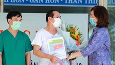 "Bệnh nhân 936" (áo trắng) nhận hoa chúc mừng từ Giám đốc Sở Y tế Ngô Thị Kim Yến. - Ảnh: Vnexpress