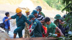 Lực lượng chức năng đưa thi thể nạn nhân vụ sạt lở ra ngoài. - Ảnh: Zing.vn