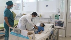 Bác sỹ Bệnh viện Đa khoa tỉnh Vĩnh Long thăm khám cho bệnh nhi bị sốc do sốt xuất huyết trong tình trạng nặng. (Ảnh: TTXVN)