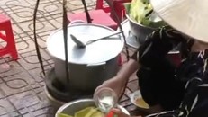 Bà H.T.T đổ nước thừa của khách vào bình. (Ảnh cắt từ clip)