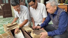 Các thành viên ban quản lý di tích Đền Quốc Tế bên các cuốn sách cổ và sắc phong hiện được lưu giữ tại nhà dân. 