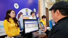 Người dân trải nghiệm đại lý dịch vụ công tại Bưu điện Trung tâm Hoàn Kiếm (Hà Nội). Ảnh: Minh Quyết/TTXVN.