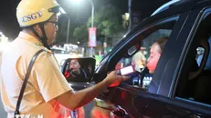 Cán bộ chiến si Đội Cảnh sát giao thông Công an thành phố Long Xuyên kiểm tra ngẫu nhiên nồng độ cồn đối với người tham gia giao thông. Ảnh: Công Mạo/TTXVN