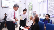 Chủ tịch Ủy ban Nhân dân phường Hồng Hà trao đổi với người dân đến làm thủ tục hành chính tại Điểm số 1-Khu vực Tứ Liên. Ảnh: Xuân Quảng/Vietnam+