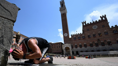 Một người đàn ông làm mát tại đài phun nước ở Siena, Italy.