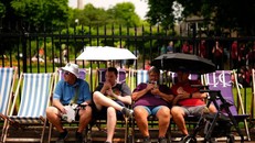 Người dân dùng ô che nắng ở London.