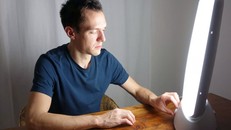 Một người đàn ông điều chỉnh hộp đèn liệu pháp của mình. Ảnh: Canva.