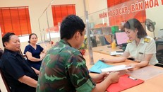 Công chức Chi cục Thuế thành phố Yên Bái hướng dẫn người dân làm thủ tục nộp thuế. Ảnh: Phạm Hậu/TTXVN