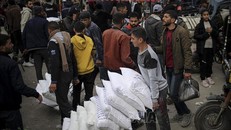 Người dân Palestine nhận lương thực viện trợ tại trung tâm phân phối của Cơ quan cứu trợ người tị nạn Palestine thuộc LHQ (UNRWA) ở Rafah, Dải Gaza. Ảnh: AFP/TTXVN