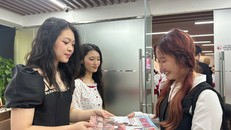 Các độc giả trẻ hào hứng nhận và đọc báo giấy của Tạp chí Ngày Nay.