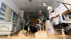 Lực lượng quân đội hỗ trợ người dân tổ 4, xã Sông Mã, Sơn La, thu gom bùn đất, cành cây, rác bị tràn về trong đợt lũ vừa qua. Ảnh: Quang Quyết