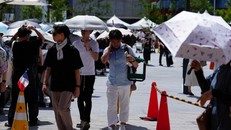 Người đi đường sử dụng ô che nắng tại Osaka, Nhật Bản.