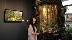 Họa sĩ Trương Kim bên một tác phẩm tại triển lãm. Ảnh: TRÀ TRƯƠNG