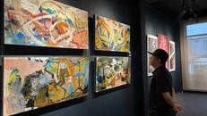 Một nhà sưu tâp thưởng lãm tranh tại triển lãm "Hi.69" vào tối 31/10