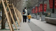 Một người mẹ dắt con đi dạo tại thành phố Thượng Hải, Trung Quốc.