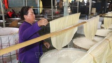 Người thợ đưa lá tàu hũ ky lên giàn phơi.