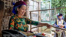 Phụ nữ H'Mông se các sợi lanh thành con sợi lớn để dệt lanh. Ảnh: Nam Thái/TTXVN.