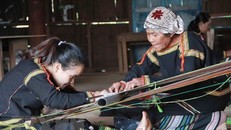 Nghệ nhân hướng dẫn lớp trẻ cách tạo nên các hoa văn thổ cẩm. Ảnh: Phạm Cường/TTXVN.