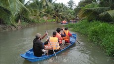 Du khách trải nghiệm hoạt động tự bơi xuồng trên sông trong Nông trại dê sữa du lịch Đông Nghi. Ảnh: Minh Hưng/TTXVN.