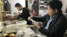 Nghệ nhân Phạm Bình Minh kiểm tra chất lượng dây truyền bạc. Ảnh: Tiến Vĩnh/TTXVN.