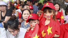 Những em nhỏ với trang phục rực rỡ cờ hoa theo người lớn đi xem diễu binh, diễu hành.