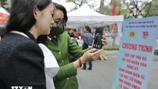 Tuổi trẻ Thủ đô hỗ trợ nhân dân đăng ký điện tử, cài đặt, sử dụng ứng dụng VNEID và thực hiện dịch vụ công trực tuyến. Ảnh: Minh Quyết/TTXVN.