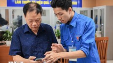 Đoàn viên thanh niên hướng dẫn người dân sử dụng, khai báo, các dịch vụ công trực tuyến trên điện thoại thông minh. Ảnh: Hoàng Hiếu/TTXVN.