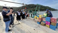 Phóng viên tác nghiệp trong chuyến công tác thăm, chúc tết cán bộ, chiến sỹ nhân dân và các lực lượng trên vùng biển Tây Nam. Ảnh: TTXVN.