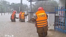 Lực lượng Công an hỗ trợ di dời người dân vùng ngập sâu đến nơi an toàn. Ảnh: TTXVN.