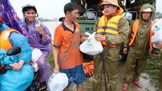 Lực lượng Công an tỉnh Đắk Lắk gửi tặng phần quà cho người dân ở vùng bị ngập sâu do nước lũ. Ảnh: Đỗ Trưởng/TTXVN.