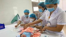 Nhân viên y tế thực hiện sàng lọc các bệnh ở trẻ sau sinh. Ảnh: PV/TTXVN.