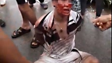 Người bị tình nghi bắt cóc bé gái bị người dân khống chế và hành hung. Ảnh cắt từ clip