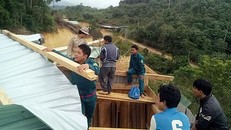 Lực lượng chức năng giúp nhân dân thôn A’choon và Ch’nốc dựng lại nhà.