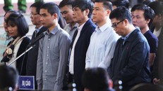 Các bị cáo đang đứng trước vành móng ngựa trong phiên xét xử 