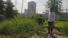 Anh Nguyễn Đức Huỳnh chỉ tay vào phần đất của gia đình mình đã bị treo chưa giải quyết các thủ tục thu hồi, bồi thường hơn chục năm qua 