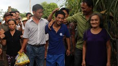 Hàng chục người thân, bà con láng giềng ùa tới ôm chầm lấy thuyền viên trở về quê sau hơn 4 năm bị cướp biển bắt giữ. Ảnh: Hải Bình.